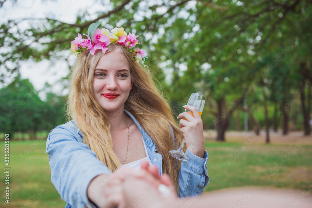 Beautiful woman holding man hand leading in public park in vacation