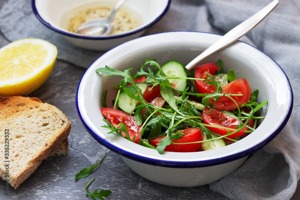 Salad with arugula, tomatoes, cucumbers and lemon sauce. Salad with arugula, tomatoes, cucumbers and lemon sauce.