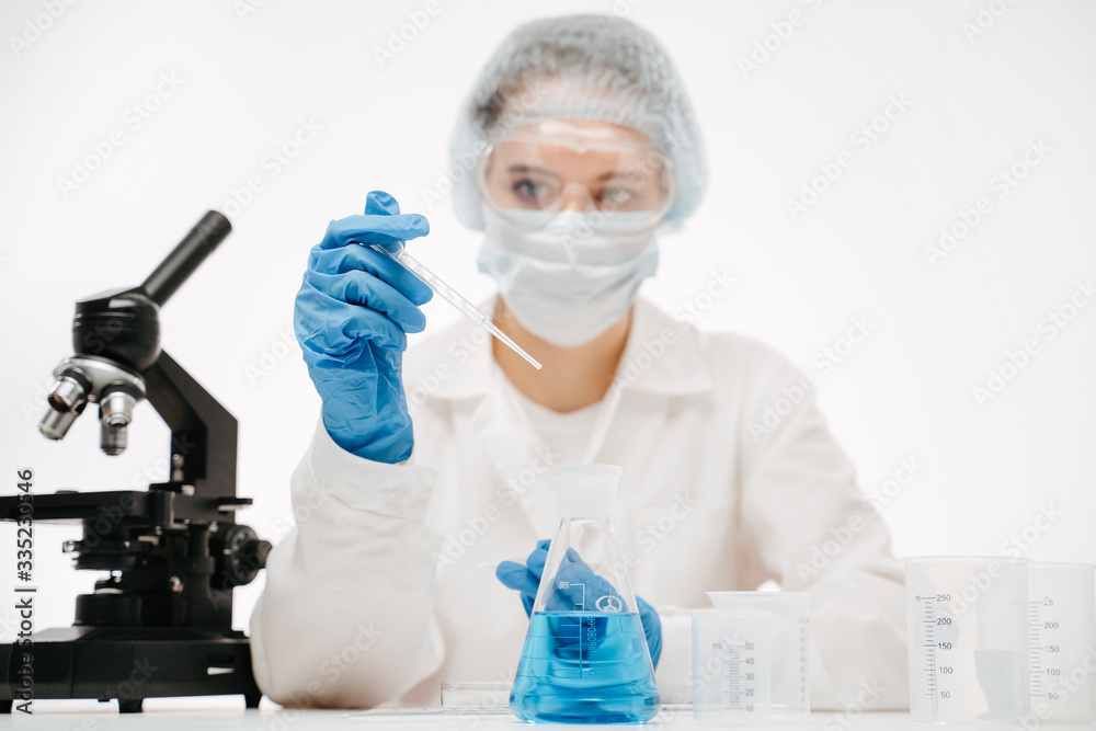 Fototapeta premium female scientist in protective uniform making coronavirus test with reagents at table with microscope in modern lab