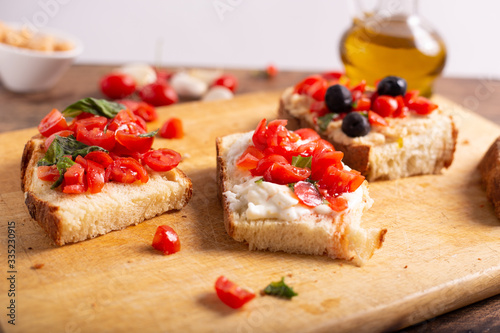 Quadro su tela Mix of bruschette with cherry tomatoes and cream cheese, hummus and black olives