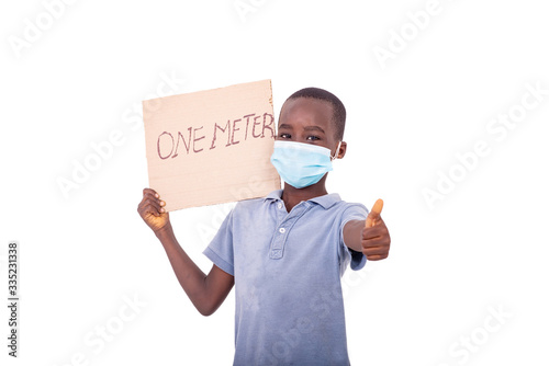 little boy holding a paper with a text ONE METER showing his thu photo