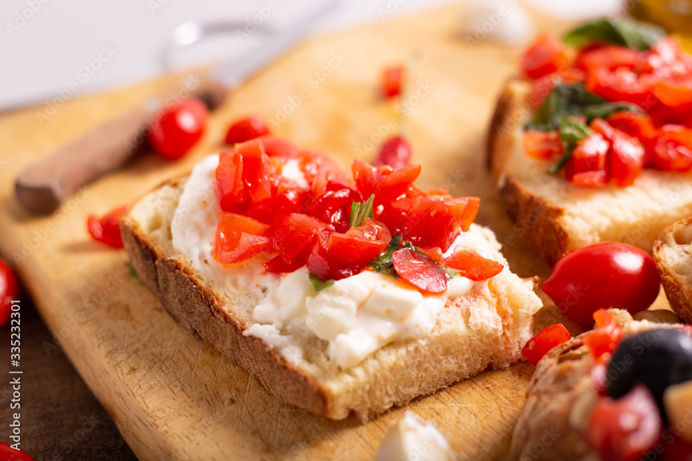 Mix of bruschette with cherry tomatoes and cream cheese, hummus and black olives. Italian food, healthy appetizer Mix of bruschette with cherry tomatoes and cream cheese, hummus and black olives. Italian food, healthy appetizer