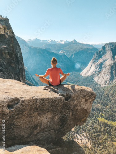 young woman meditating in the mountains