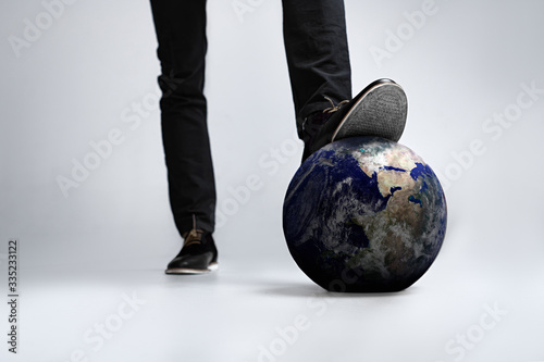 A man stepped on planet earth in shoes, trample the planet all on a white background and close-up