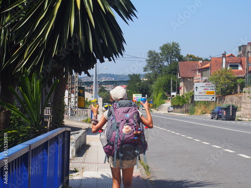 Pilgrim walking while peace sign, Camino de Santiago, Way of St. James, Journey from Valenca to Cesantes, Portuguese way, Portugal