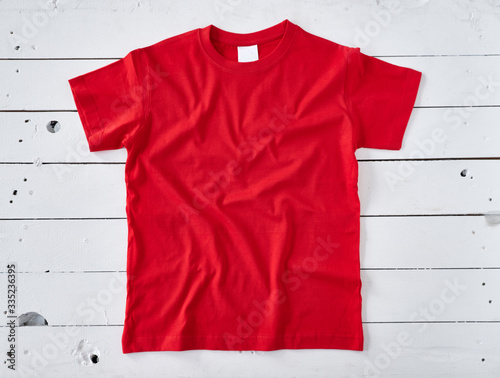 Red t-shirt on white wooden background