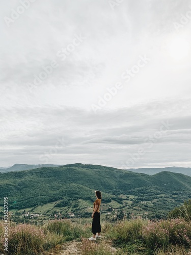 Beautiful young girl enjoying the mountain view. Travel journey trip concept. Mountains rocks background.