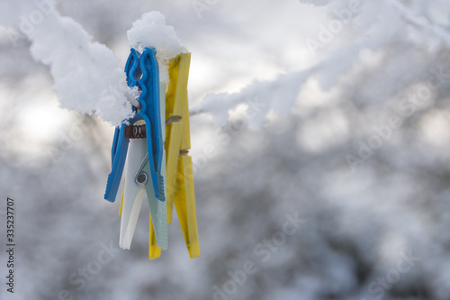 snowy clothespins on a clothesline in winter