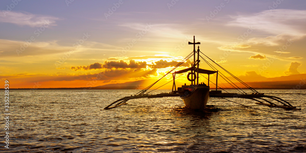 silhouette of boat on the beach during sunset in philippines 