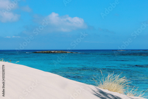 Tropical beach with white sand dune in front and azure water sea. Beach and sea photo