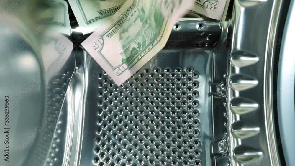Washing banknotes in machine, money laundering, financial fraud concept. 4K high resolution video
