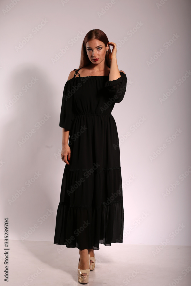 Beautiful woman in black dress on bright background Beautiful woman in black dress on bright background