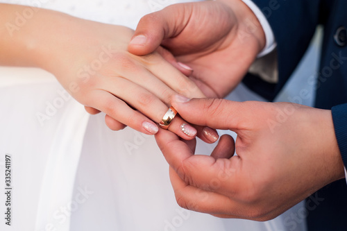  on the wedding day, the husband puts on a wedding ring to the bride in a white dress and it is happiness when two lovers' hearts are united in a family