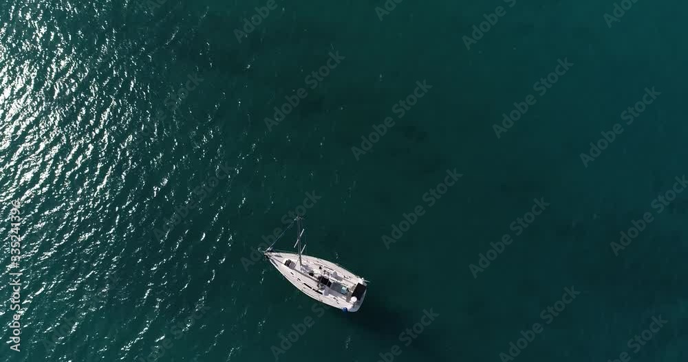 Aerial point of view, sailboat off the coast of Caribbean, in deep blue water Aerial point of view, sailboat off the coast of Caribbean, in deep blue water