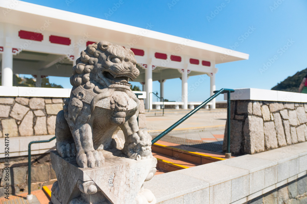 Naklejka premium Beautiful Lion stone statue, Victoria Peak Gardens. Pavilion built on the site of the former Mountain Lodge (an alternate residence for the Governor of Hong Kong). Symbol of power.