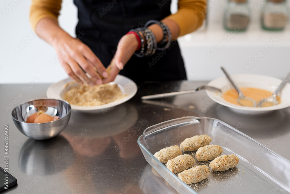Close up of woman hands cooking homemade croquettes at home