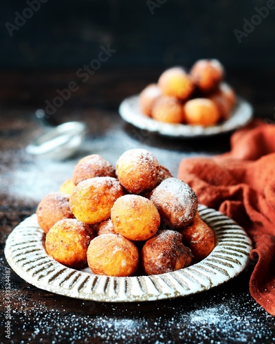 Cottage cheese donuts in a ceramic dish on a dark wooden table