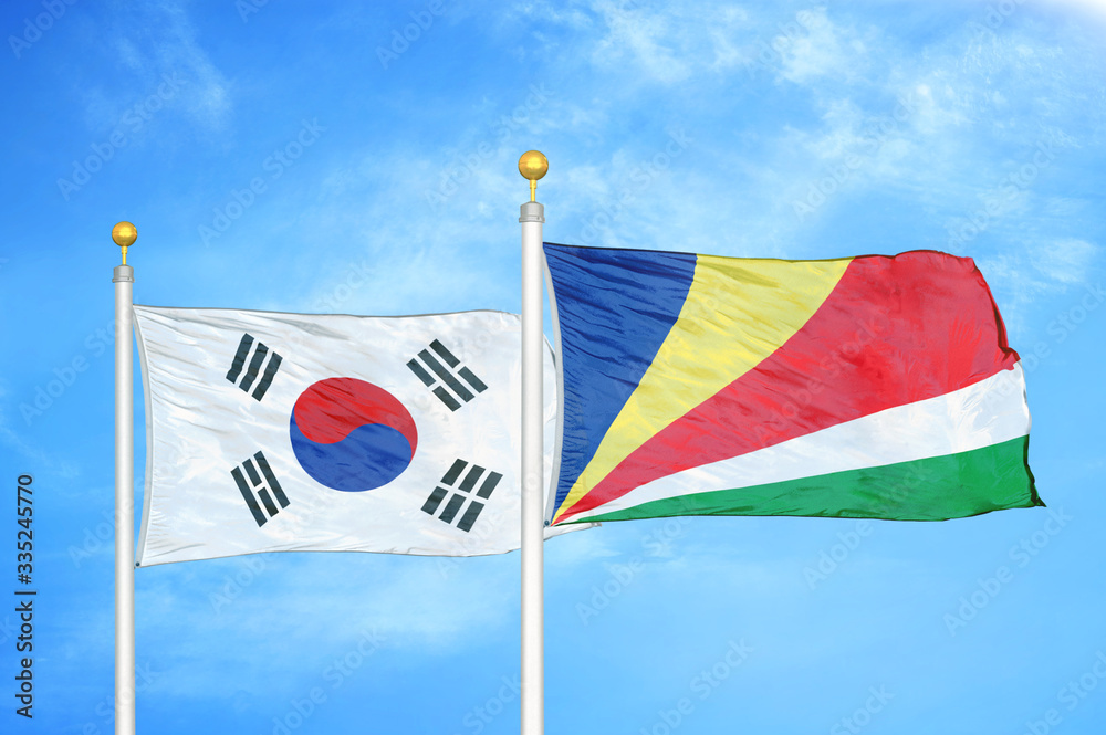 Naklejka premium South Korea and Seychelles two flags on flagpoles and blue cloudy sky