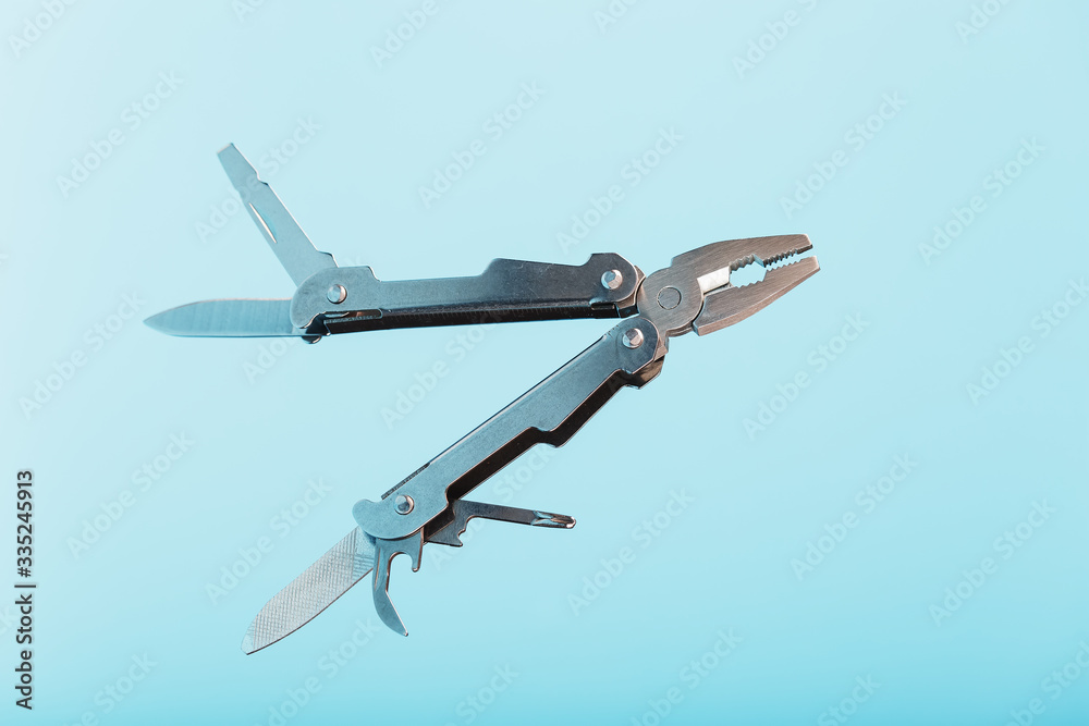 The multitool multi-function tool hovers on a blue background. The concept of an expanded multi-tool with free space. The multitool multi-function tool hovers on a blue background. The concept of an expanded multi-tool with free space.