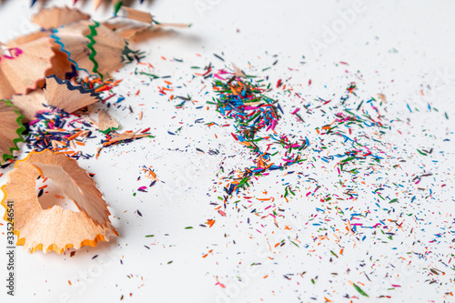 Colorful pencil shavings on white background.