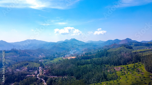 Tea plantations in Munnar, Kerala, India. Beautiful views of green hills with blue sky.