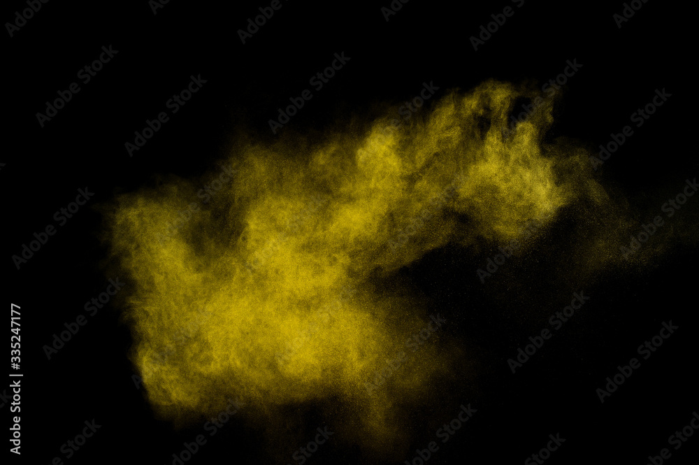 Yellow powder explosion on black background. Colored powder cloud. Colorful dust explode. Paint  Holi.