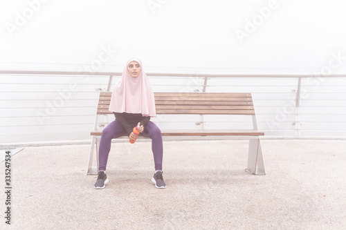 Attractive tired sportswoman with bottle of water stock photo