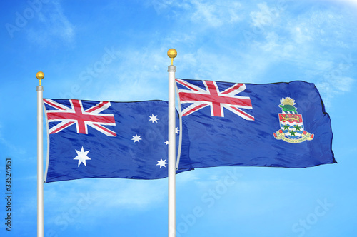 Australia and Cayman Islands two flags on flagpoles and blue cloudy sky photo