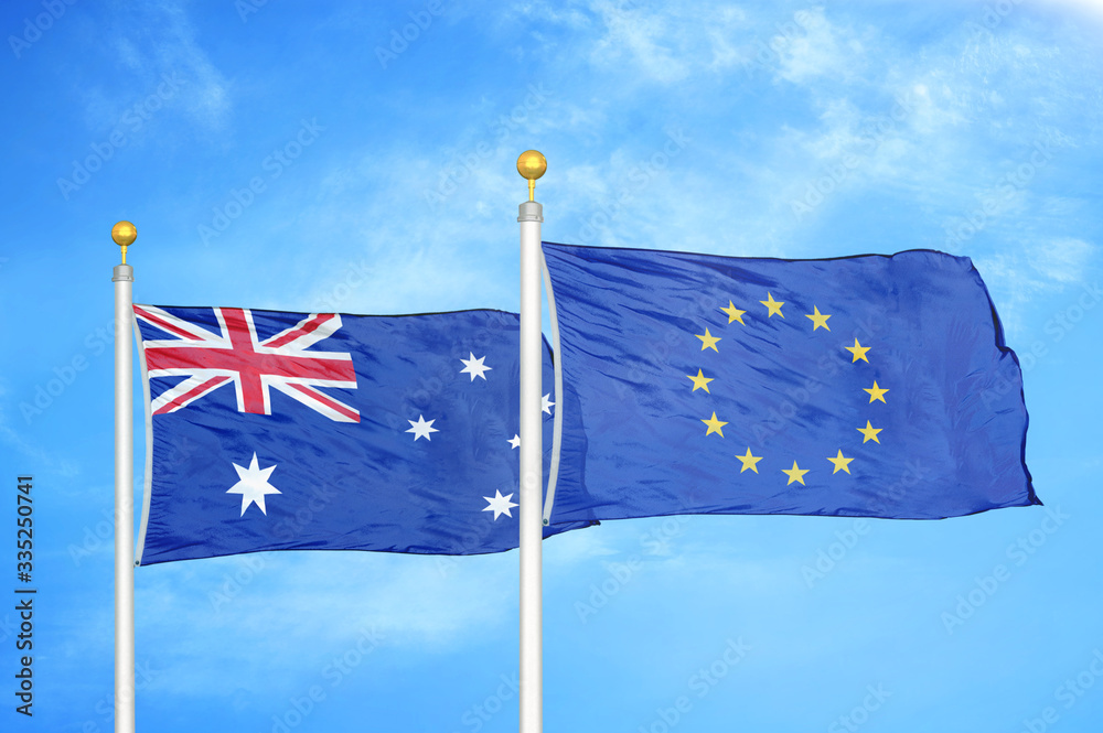 Fototapeta premium Australia and European Union two flags on flagpoles and blue cloudy sky