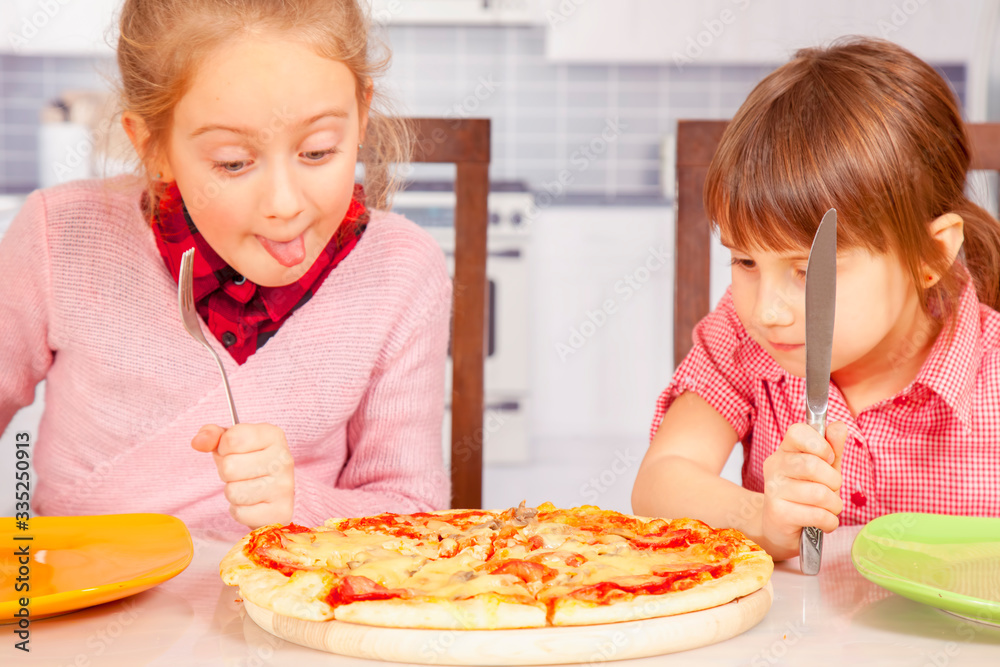 We love pizza! Cute little child girls eating pizza. We love pizza! Cute little child girls eating pizza.
