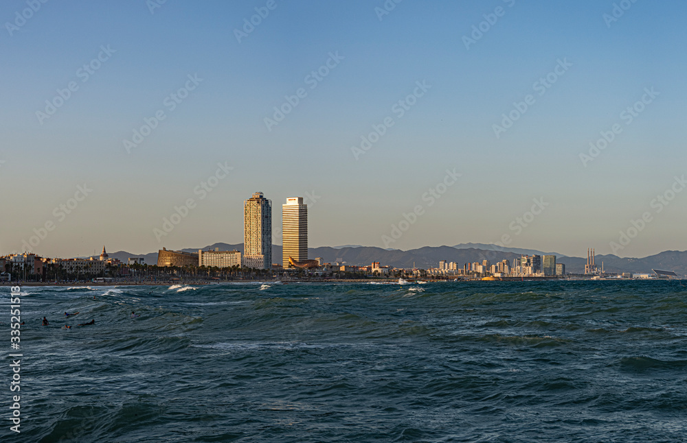 beach of the capital city, the sea is mixed with waves, the sky with clouds and tall buildings with skyscrapers in the background, there is a famous hotel