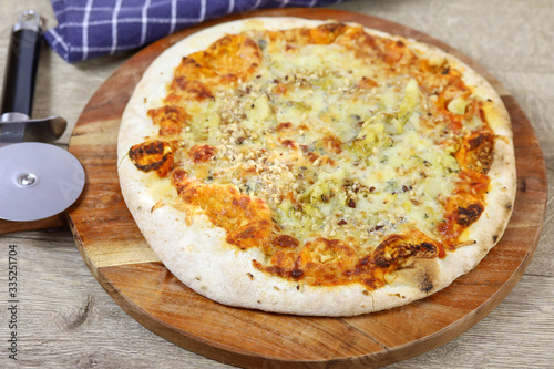 pizza aux gorgonzola et noisettes sur une planche à découper