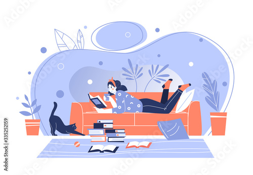 Woman at home, lying on the sofa, reading books. Home library. The concept of reading paper literature. Young adult woman having a rest with good book. Girl enjoying himself at home.