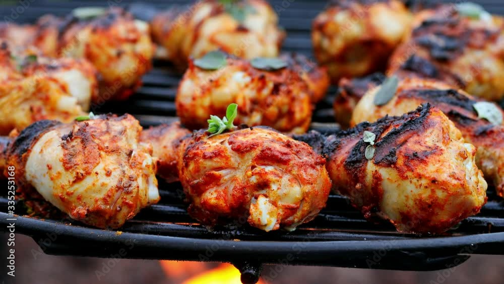 Closeup of spicy grilled chicken leg with spices on grill