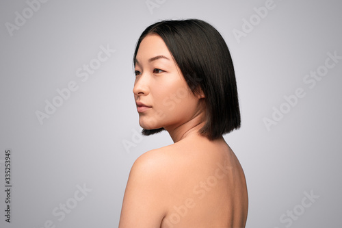 Young Asian woman with naked back looking away