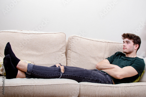 A young adult man on a sofa