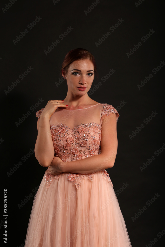 Pretty woman wearing pink dress on black background Pretty woman wearing pink dress on black background