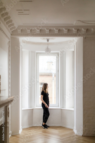 Girl in black clothes near the bay window