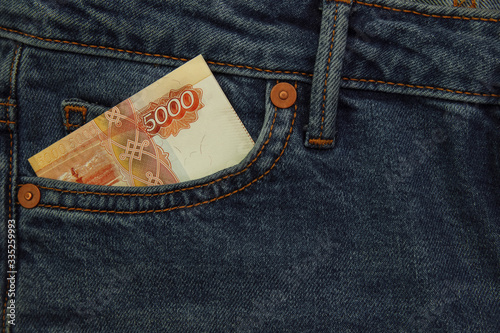 Cash bill Russian rubles in the pocket of jeans trousers close up photo