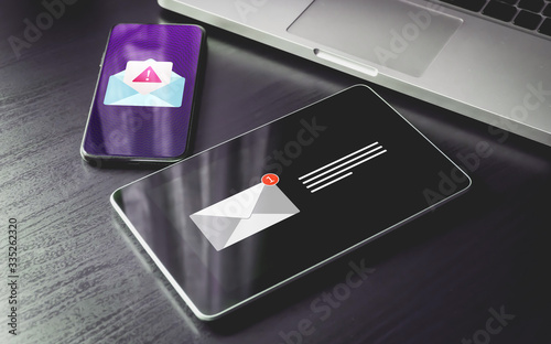 Malware Spreading Virus, Spam Distribution - smartphone and tablet pc with mail notification alert and warning message icon. Irrelevant unsolicited malicious software, scam, fraud e-mail concept.
