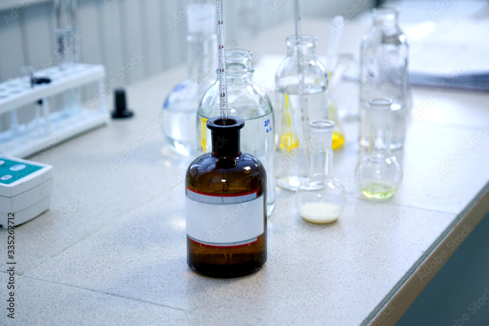 research on the development of a vaccine against the covid-19 virus. glass jar with samples of a new formula, laboratory conditions.