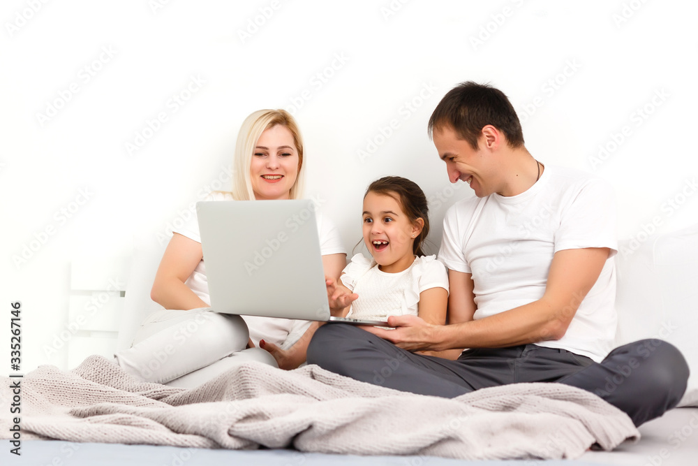 Family Lying In Bed Together Using Digital Devices Family Lying In Bed Together Using Digital Devices