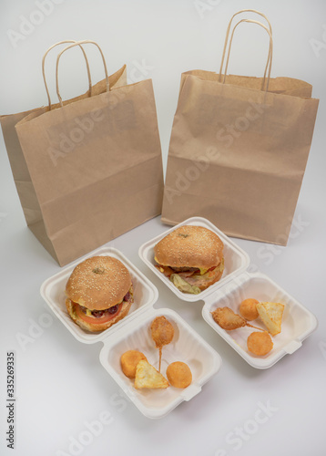 Delivery of the Burger in a cardboard box and paper bag. The concept of food delivery.