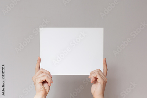 Hands hold a white sheet. Empty space for the label.