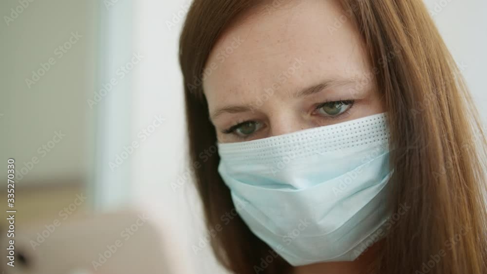 a woman in a medical mask using a smartphone a woman in a medical mask using a smartphone