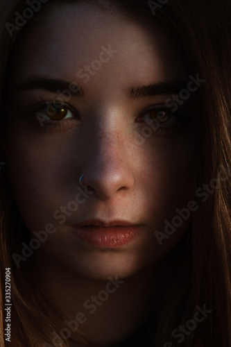  Realistic portrait of the face of a beautiful young woman with brown eyes, freckles and nose piercing, with natural light