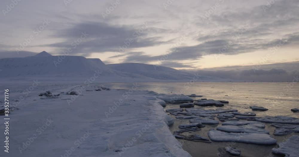 Ice Floes floating infront of dramatic landscape in the sunset on Svalbard. Ice Floes floating infront of dramatic landscape in the sunset on Svalbard.