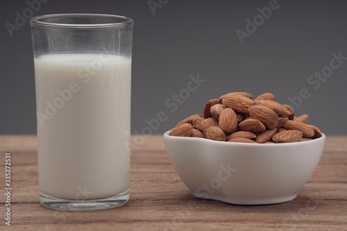 Almonds in white porcelain bowl on wooden table