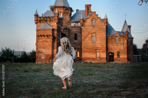 blonde girl in a white dress on nature near architectural monuments in the open air