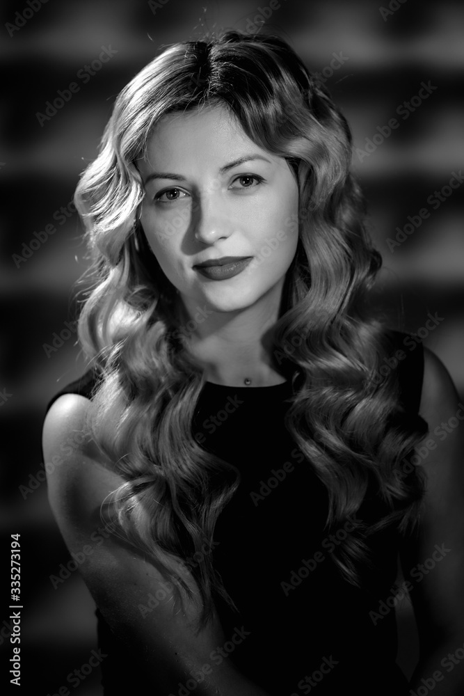 Fashion studio portrait of beautiful girl with blonde curly hair. image in black and white conversion